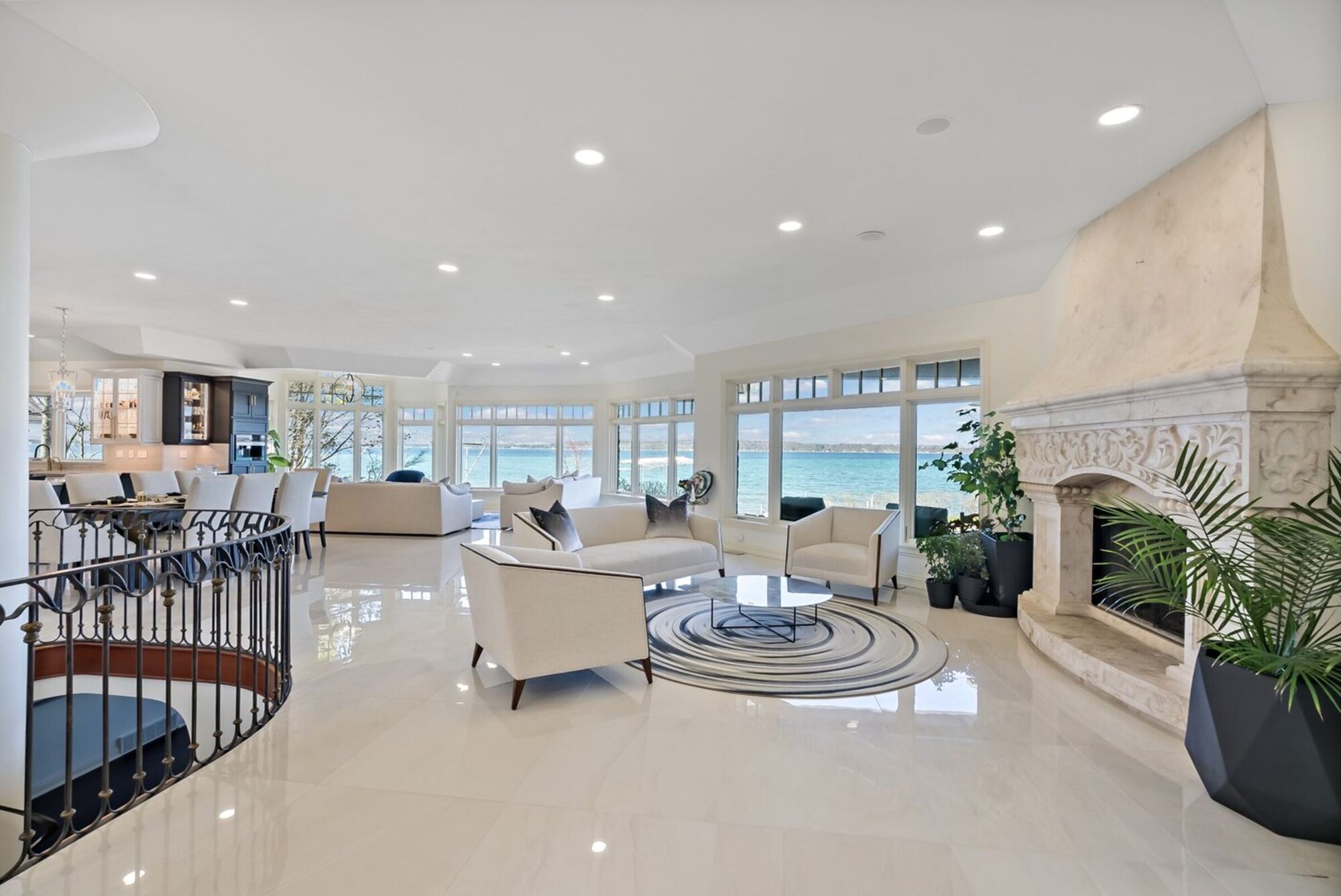 A finished lakefront great room: polished large-format porcelain running unbroken to a wall of windows over the water.