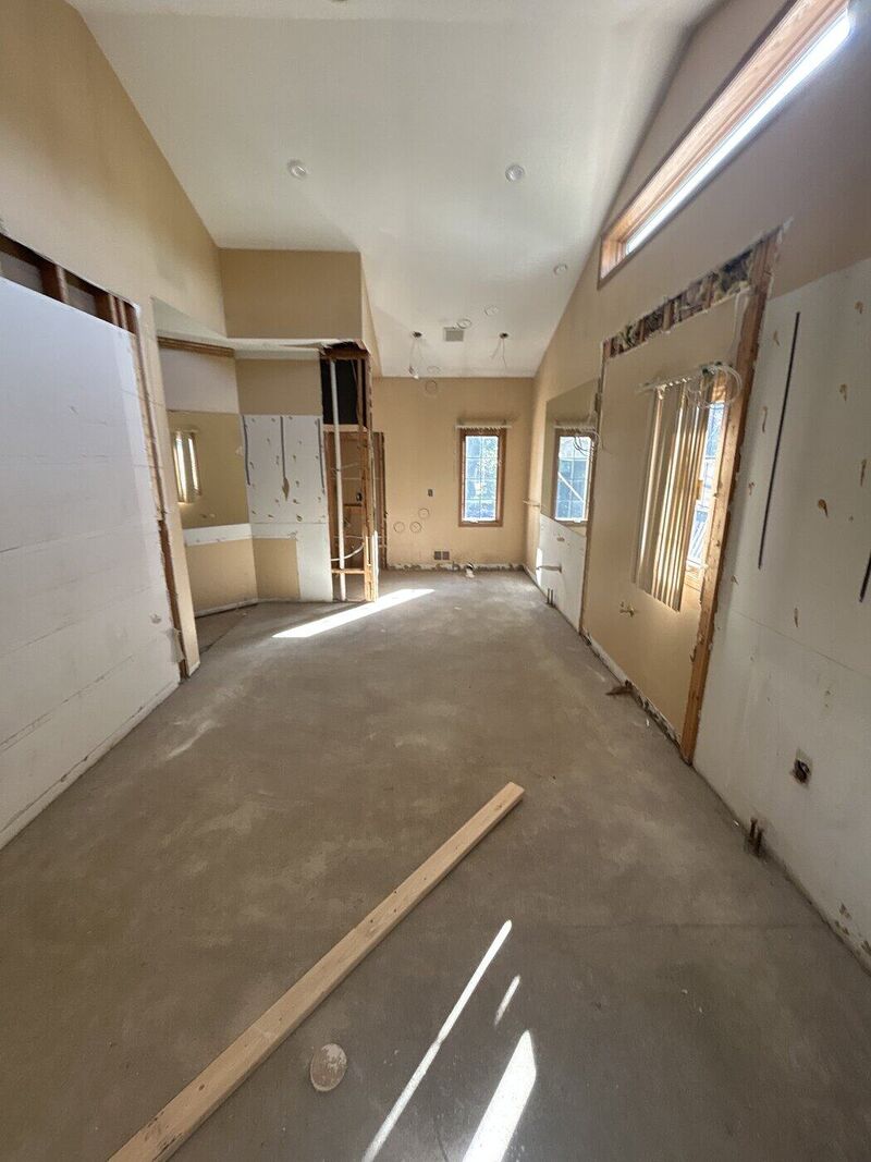 From inside the shower, looking out toward the toilet and cabinet. Primary bath, High-End Slab Bath